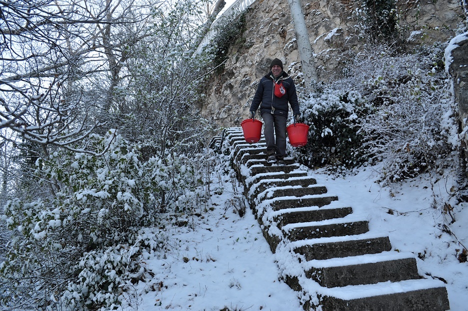 A person carrying red buckets on a snowy staircase
AI-generated content may be incorrect.